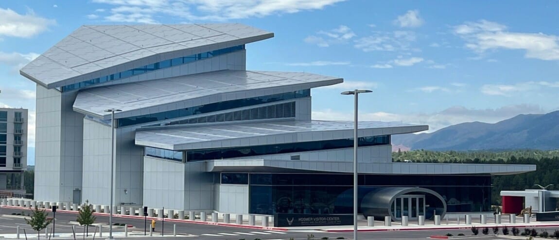 Modern building with an empty parking lot, text reads: 
