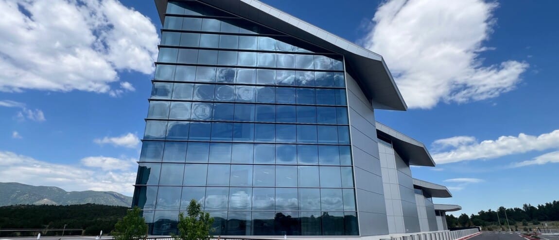 Modern building with reflective glass, under a blue sky
