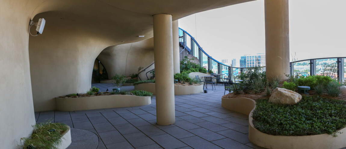 Curved architectural space with planters and outdoor seating.