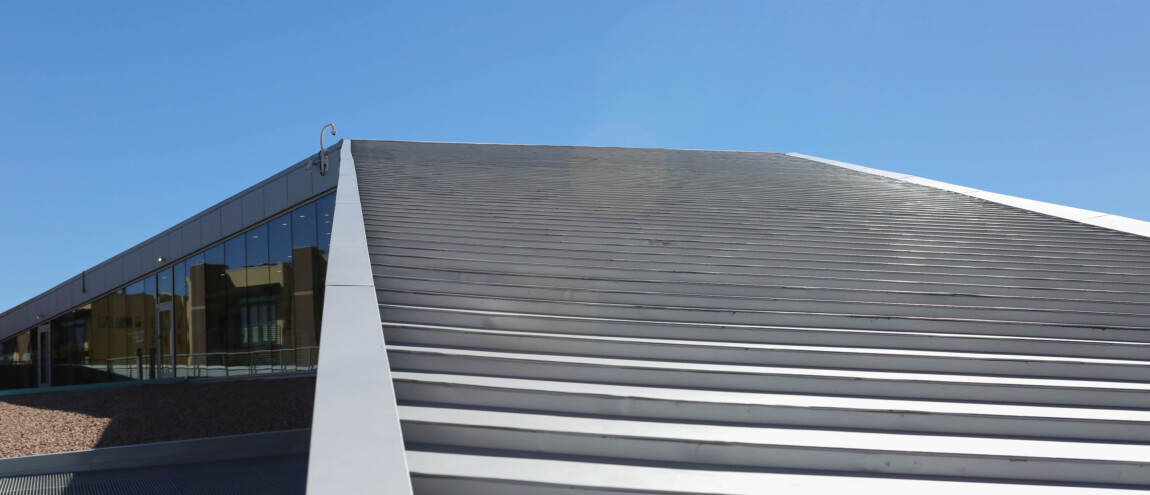 Modern metal and glass building exterior against blue sky