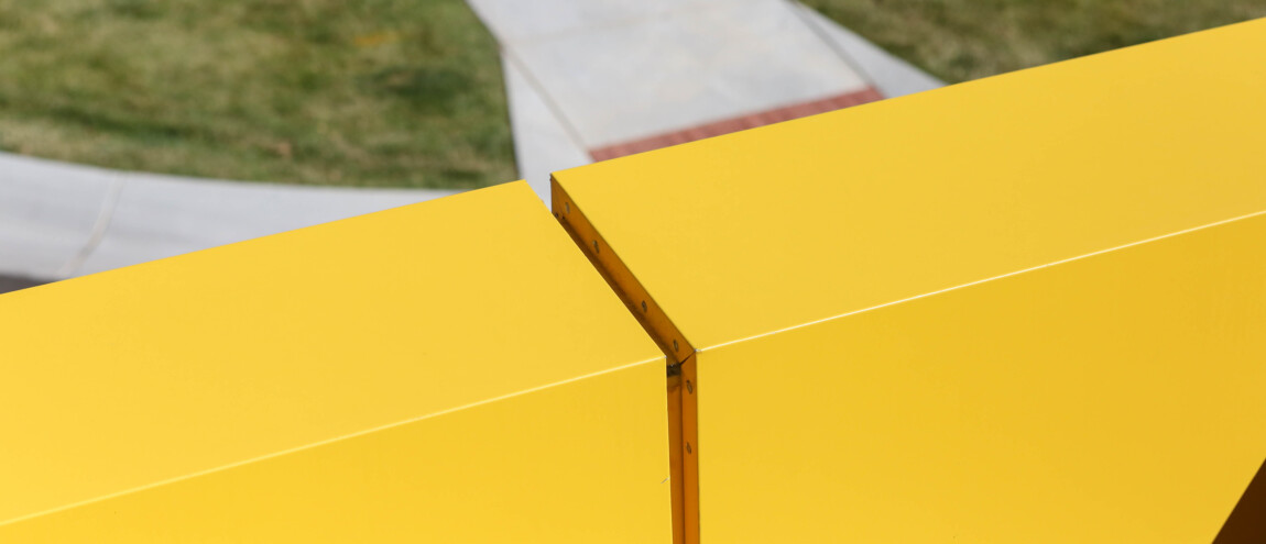 Close-up of two yellow geometric structures outdoors.