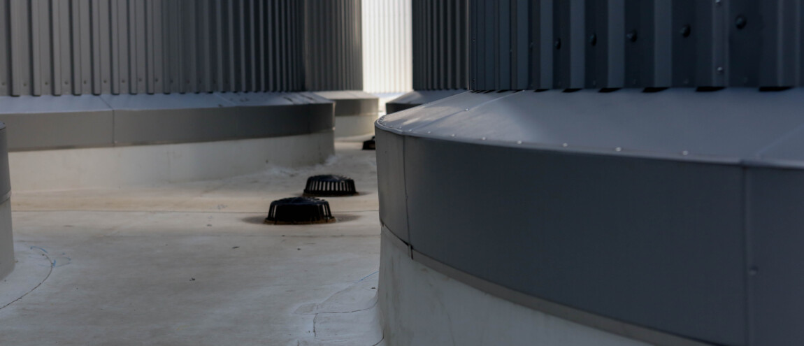 Gray industrial structure with circular vents and corrugated metal walls