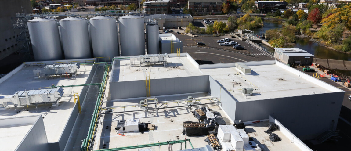 Rooftop view of an industrial facility with hills nearby