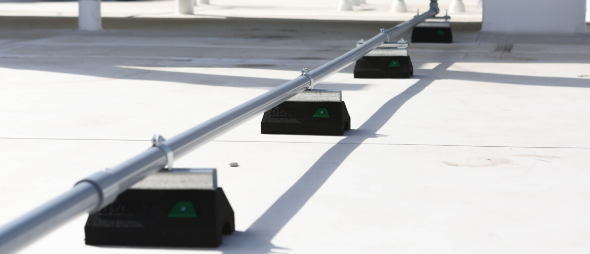 Metal pipe supported by rooftop blocks in industrial setting