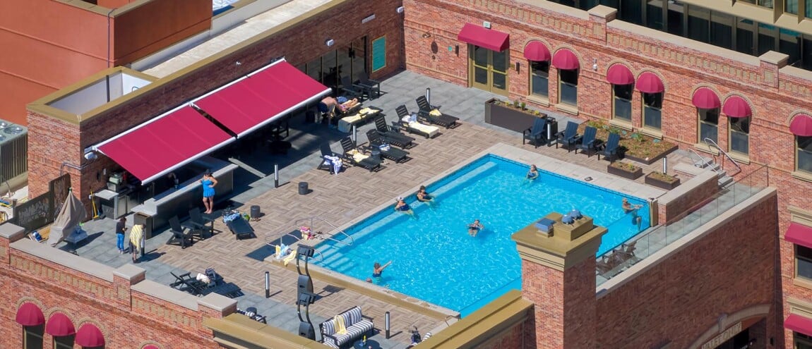 Aerial view of a rooftop pool with lounge chairs.