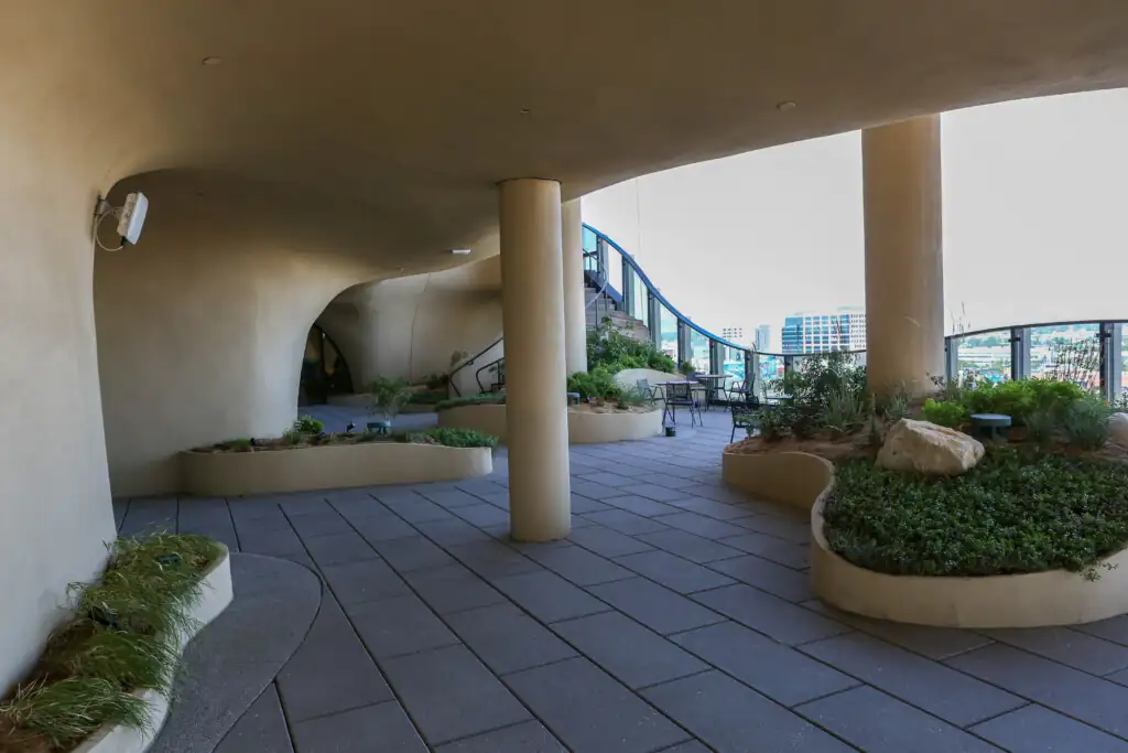 Curved architectural space with planters and outdoor seating.