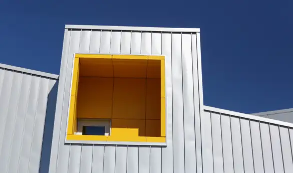 Modern building with a yellow window against blue sky