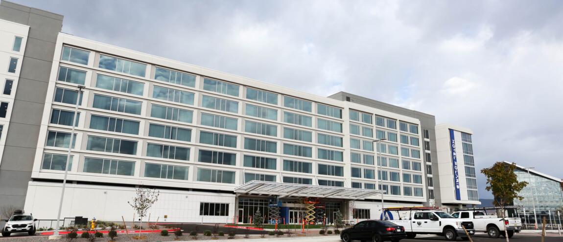 Modern hotel with large windows and parking lot. Hotel Local.