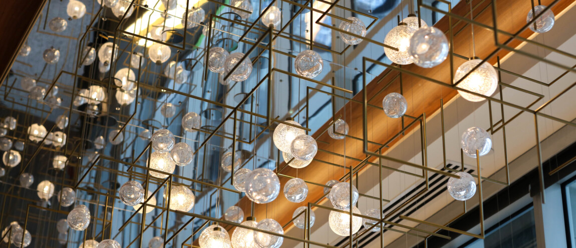 Hanging spherical light fixtures with geometric frames in a building