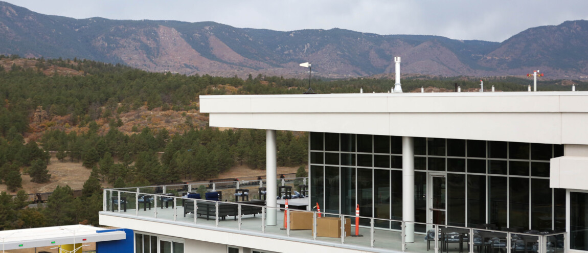 Building with large windows and patio, mountain backdrop