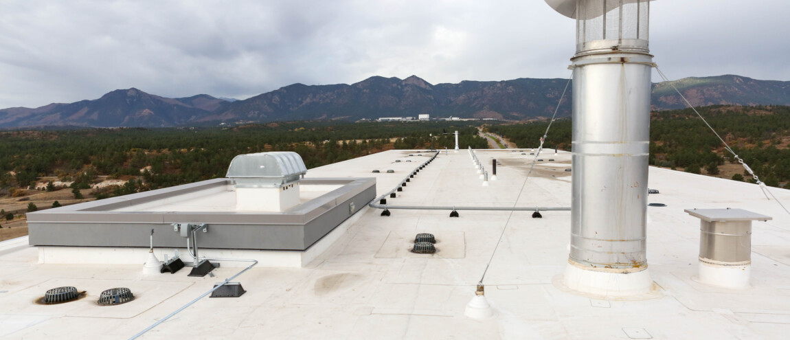 Rooftop with vents and mountains in the background