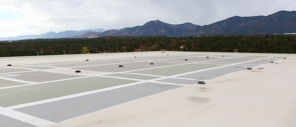Rooftop with skylights and distant mountain landscape.