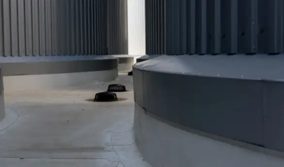 Gray industrial structure with circular vents and corrugated metal walls