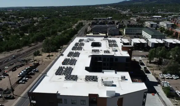 Aerial view of building with "DORIAN" on side, mountains background