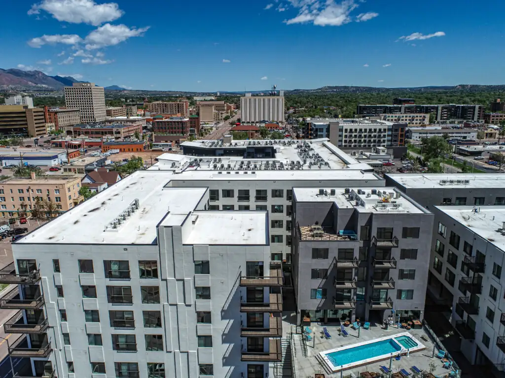 Aerial view of buildings with a rooftop pool.