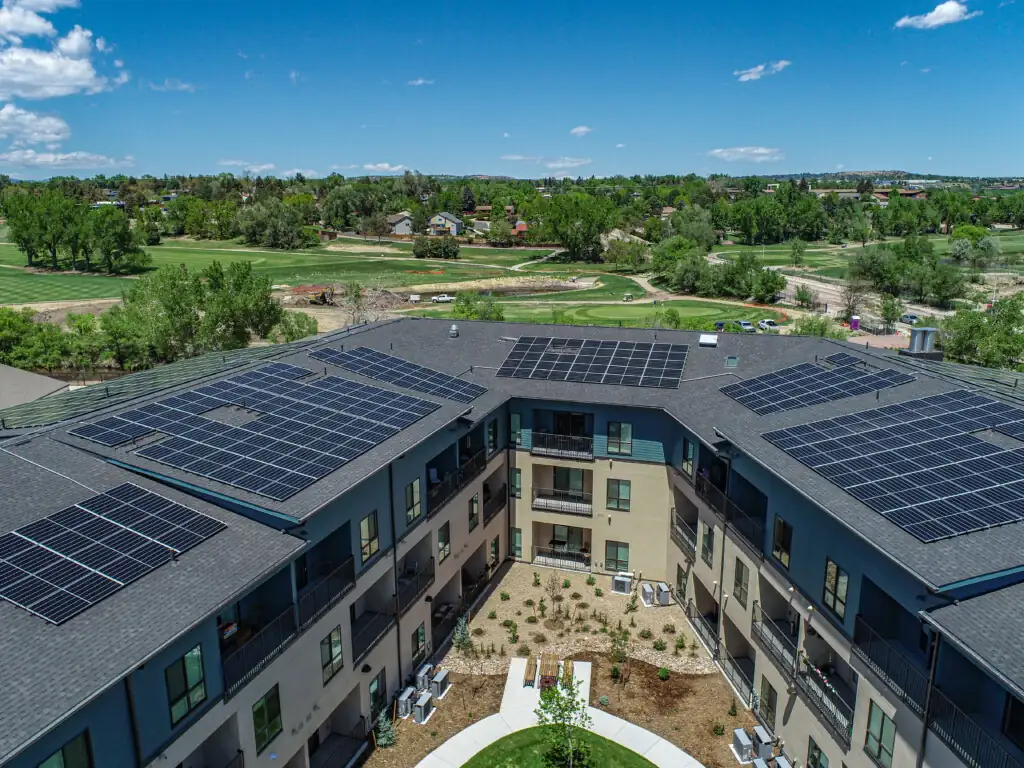 Aerial view of building with solar panels on roof.