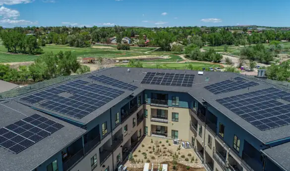 Aerial view of building with solar panels on roof.